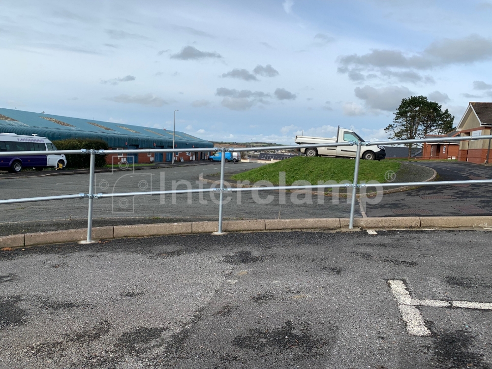 Interclamp key clamp fittings and tube used to construct a sturdy guardrail at an industrial car park, ensuring the safety of vehicles and pedestrians.